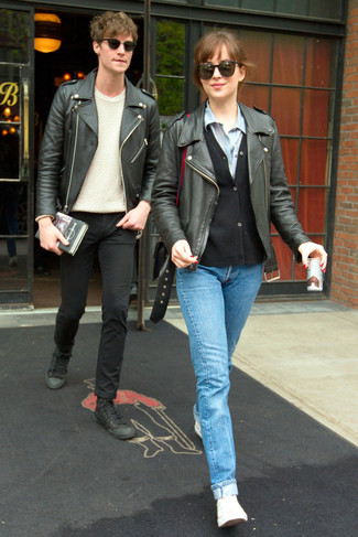 Dakota Johnson trägt schwarze Leder Bikerjacke, schwarze Strickjacke, hellblaues Jeanshemd, hellblaue Jeans