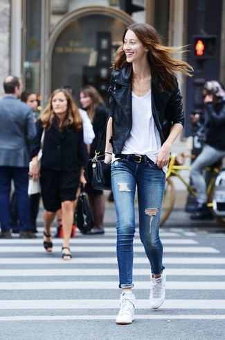 Lässige kühl Wetter Outfits Damen 2024: Eine schwarze Leder Bikerjacke und blaue enge Jeans mit Destroyed-Effekten erzielen ein entspanntes City-Outfit, das aber immer schick bleibt. Weiße hohe sneakers sind eine perfekte Wahl, um dieses Outfit zu vervollständigen.