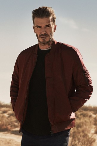 David Beckham trägt dunkelrote Bomberjacke, schwarzer Pullover mit einem Rundhalsausschnitt, graues T-Shirt mit einem Rundhalsausschnitt, dunkelblaue Chinohose