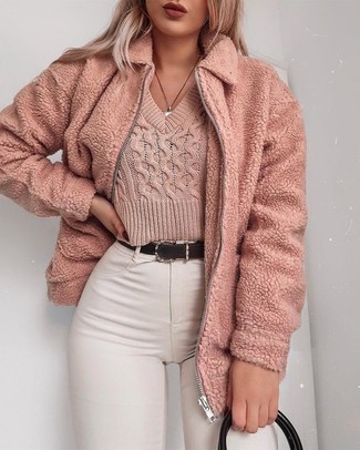 rosa Fleece-Bomberjacke, rosa kurzer Pullover, weiße enge Jeans, schwarze Shopper Tasche aus Leder für Damen