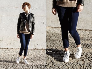 schwarze Leder Bomberjacke, beige Pullover mit einem Rundhalsausschnitt, dunkelblaue enge Jeans, weiße niedrige Sneakers für Damen
