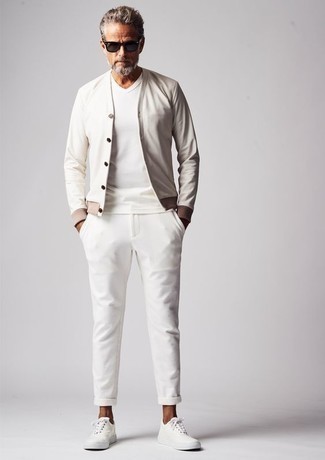 weiße Bomberjacke, weißes T-Shirt mit einem V-Ausschnitt, weiße Chinohose, weiße Segeltuch niedrige Sneakers für Herren
