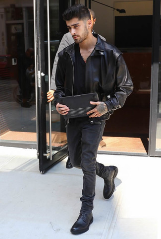 Zayn Malik trägt schwarze Leder Bomberjacke, schwarzes T-Shirt mit einem V-Ausschnitt, schwarze Jeans, schwarze Lederfreizeitstiefel