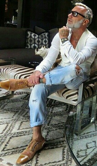 Gianluca Vacchi trägt weißes Businesshemd, hellblaue Jeans mit Destroyed-Effekten, beige Wildleder Oxford Schuhe, schwarze Sonnenbrille