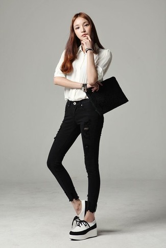 weißes Businesshemd, schwarze enge Jeans mit Destroyed-Effekten, weiße und schwarze klobige Leder Oxford Schuhe, schwarze Wildleder Clutch für Damen