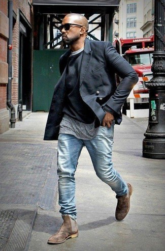 Kanye West trägt schwarze Cabanjacke, schwarzer Pullover mit einem Rundhalsausschnitt, graues T-Shirt mit einem Rundhalsausschnitt, hellblaue Jeans