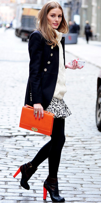 Olivia Palermo trägt dunkelblaue Cabanjacke, weißer Strickpullover, weißer und schwarzer Minirock mit Leopardenmuster, schwarze Leder Stiefeletten