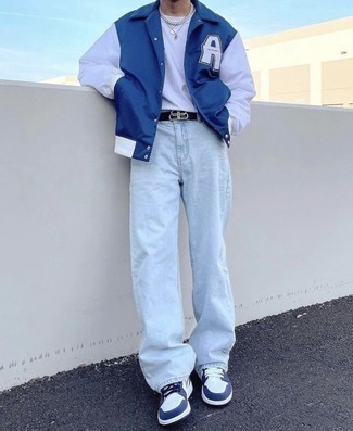 dunkelblaue bedruckte Collegejacke, weißes Langarmshirt, hellblaue Jeans, weiße und dunkelblaue Leder niedrige Sneakers für Herren