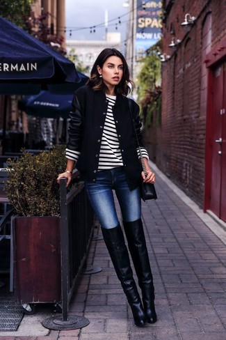 schwarze Collegejacke, weißer und schwarzer horizontal gestreifter Pullover mit einem Rundhalsausschnitt, dunkelblaue enge Jeans, schwarze Overknee Stiefel aus Leder für Damen