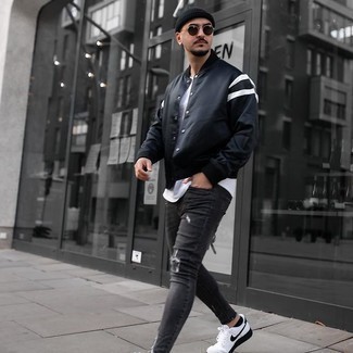 Graue Jeans mit Destroyed-Effekten kombinieren – 500+ Herren Outfits: Entscheiden Sie sich für Komfort in einer schwarzen Collegejacke und grauen Jeans mit Destroyed-Effekten. Fühlen Sie sich ideenreich? Ergänzen Sie Ihr Outfit mit weißen und schwarzen Segeltuch niedrigen Sneakers.