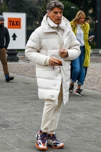 Herren Outfits 2022: Kombinieren Sie einen weißen Daunenmantel mit einer hellbeige Chinohose für ein bequemes Outfit, das außerdem gut zusammen passt. Wenn Sie nicht durch und durch formal auftreten möchten, entscheiden Sie sich für mehrfarbigen Sportschuhe.