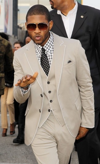Usher trägt hellbeige Dreiteiler, weißes und schwarzes Businesshemd mit Karomuster, schwarze und weiße gepunktete Krawatte, schwarzes und weißes gepunktetes Einstecktuch