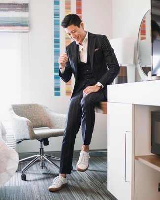 Beige bedrucktes Einstecktuch kombinieren – 54 Smart-Casual Herren Outfits: Entscheiden Sie sich für einen schwarzen vertikal gestreiften Dreiteiler und ein beige bedrucktes Einstecktuch, um einen lockeren, aber dennoch stylischen Look zu erhalten. Weiße Segeltuch niedrige Sneakers sind eine perfekte Wahl, um dieses Outfit zu vervollständigen.