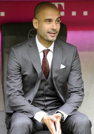 Pep Guardiola trägt grauer Dreiteiler, weißes Businesshemd, dunkelrote bedruckte Krawatte, weißes Einstecktuch