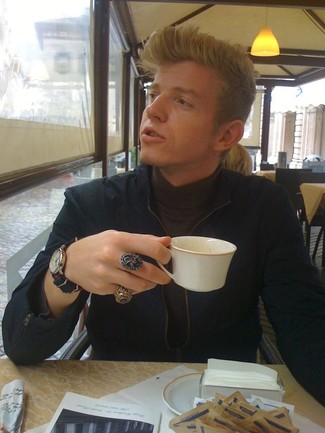 Alexander Zaytsev trägt dunkelblaue Bomberjacke, dunkelbrauner Rollkragenpullover