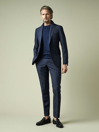 50 Jährige: Dunkelblauen Anzug kombinieren – 200 Herren Outfits: Kombinieren Sie einen dunkelblauen Anzug mit einem dunkelblauen Pullover mit einem Rundhalsausschnitt, um vor Klasse und Perfektion zu strotzen. Schwarze Leder Slipper sind eine kluge Wahl, um dieses Outfit zu vervollständigen.