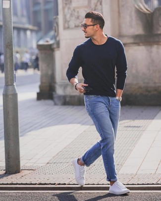 dunkelblauer Pullover mit einem Rundhalsausschnitt, blaue Jeans, weiße niedrige Sneakers für Herren