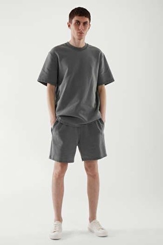 Graue Shorts kombinieren – 432 Herren Outfits: Entscheiden Sie sich für Komfort in einem dunkelgrauen T-Shirt mit einem Rundhalsausschnitt und grauen Shorts. Weiße Segeltuch niedrige Sneakers sind eine perfekte Wahl, um dieses Outfit zu vervollständigen.