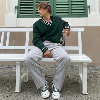 dunkelgrüner Pullover mit einem V-Ausschnitt, graue Chinohose, weiße und grüne Leder niedrige Sneakers für Herren