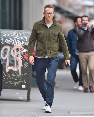 Ryan Reynolds trägt olivgrüne Feldjacke aus Wildleder, weißes T-Shirt mit einem Rundhalsausschnitt, dunkelblaue Chinohose, weiße Segeltuch niedrige Sneakers