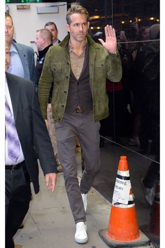 Ryan Reynolds trägt olivgrüne Feldjacke aus Wildleder, dunkelbraune Weste, hellbeige Businesshemd, graue Chinohose