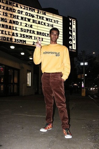 gelbes bedrucktes Sweatshirt, braune Cord Chinohose, mehrfarbige bedruckte hohe Sneakers aus Segeltuch für Herren