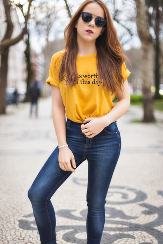 Gelbes bedrucktes T-Shirt mit einem Rundhalsausschnitt kombinieren – 10 Damen Outfits: Wenn Sie einen aufregenden Freizeit-Look erzielen möchten, bleiben ein gelbes bedrucktes T-Shirt mit einem Rundhalsausschnitt und dunkelblaue enge Jeans ein Klassiker.