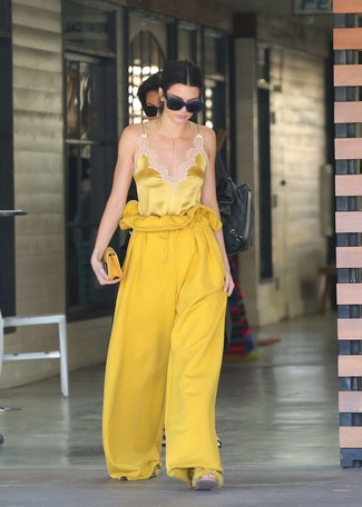 Gelbe weite Hose kombinieren – 35 Damen Outfits: Probieren Sie die Kombi aus einem gelben Seide Trägershirt und einer gelben weiter Hose, um einen stilvollen Freizeit-Look zu erreichen.