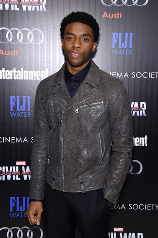 Chadwick Boseman trägt graue Leder Bikerjacke, dunkelblaues Businesshemd, schwarze Anzughose