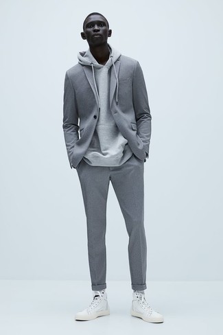 20 Jährige: Hohe Sneakers kombinieren – 56 Smart-Casual Herren Outfits: Kombinieren Sie einen grauen Anzug mit einem grauen Pullover mit einem Kapuze, um einen modischen Freizeitlook zu kreieren. Fühlen Sie sich ideenreich? Komplettieren Sie Ihr Outfit mit hohen Sneakers.