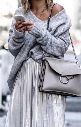 Silbernen Midirock mit Falten kombinieren – 43 Damen Outfits: Um einen einfachen aber glamurösen Alltags-Look zu schaffen, wahlen Sie einen grauen Oversize Pullover und einen silbernen Midirock mit Falten.