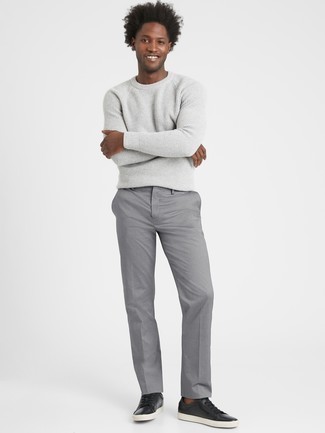 grauer Pullover mit einem Rundhalsausschnitt, graue Chinohose, schwarze Leder niedrige Sneakers für Herren
