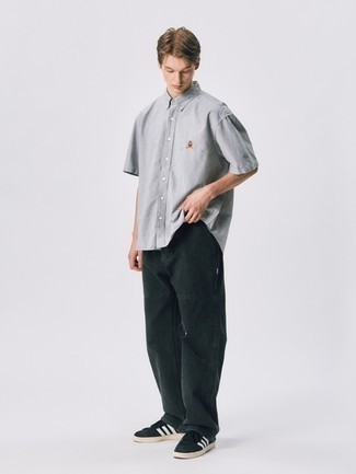 Casual Sommer Outfits Herren 2024: Kombinieren Sie ein graues Kurzarmhemd mit schwarzen Jeans für ein großartiges Wochenend-Outfit. Schwarze und weiße Wildleder niedrige Sneakers sind eine perfekte Wahl, um dieses Outfit zu vervollständigen. Ein schöner Sommer-Look.