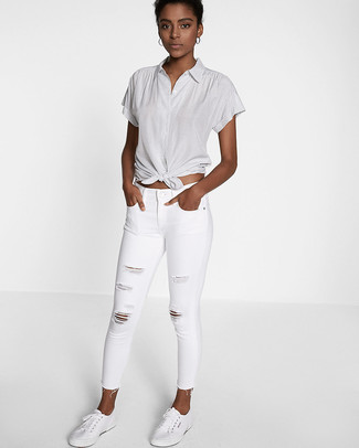 Weiße enge Jeans mit Destroyed-Effekten kombinieren – 129 Damen Outfits: Erwägen Sie das Tragen von einem grauen Kurzarmhemd und weißen engen Jeans mit Destroyed-Effekten, um ein stilvolles Freizeit-Outfit zu schaffen. Wenn Sie nicht durch und durch formal auftreten möchten, vervollständigen Sie Ihr Outfit mit weißen niedrigen Sneakers.