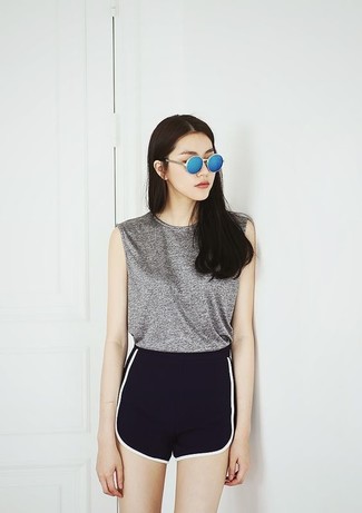 graues Trägershirt, schwarze und weiße Shorts, blaue Sonnenbrille für Damen