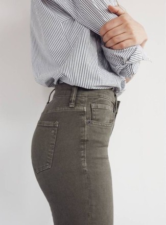 Dunkelgrüne enge Jeans kombinieren – 66 Damen Outfits: Die Kombi aus einem grauen vertikal gestreiften Businesshemd und dunkelgrünen engen Jeans schafft die ideale Balance zwischen schlichtem Trend-Look und zeitgenössische Aussehen.