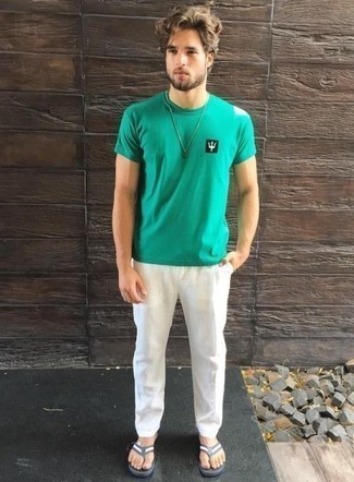 grünes bedrucktes T-Shirt mit einem Rundhalsausschnitt, weiße Chinohose, dunkelblaue und weiße Zehensandalen für Herren