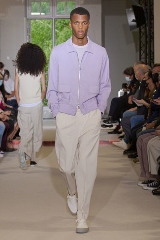 Frühling Outfits Herren 2024: Kombinieren Sie eine hellviolette Harrington-Jacke mit einer hellbeige Chinohose für einen bequemen Alltags-Look. Machen Sie diese Aufmachung leger mit weißen Segeltuch niedrigen Sneakers. Ein schönes Frühlings-Outfit.