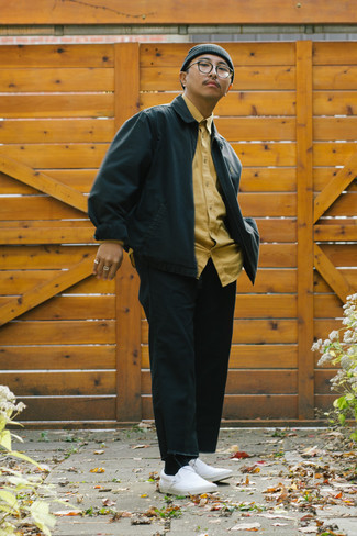 dunkelblaue Harrington-Jacke, gelbes Langarmhemd, schwarze Jeans, weiße Slip-On Sneakers aus Segeltuch für Herren