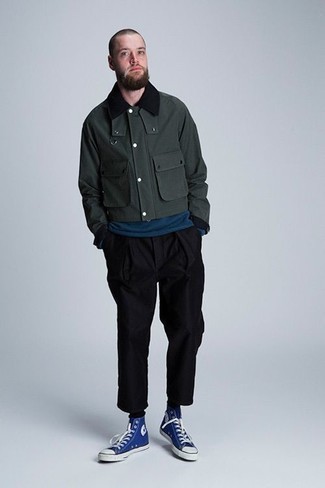 dunkelgrüne Harrington-Jacke, dunkeltürkises Langarmshirt, schwarze Chinohose, blaue hohe Sneakers aus Segeltuch für Herren