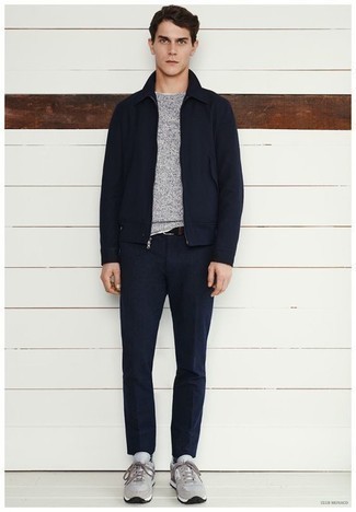 dunkelblaue Harrington-Jacke, grauer Pullover mit einem Rundhalsausschnitt, dunkelblaue Anzughose, graue Sportschuhe für Herren