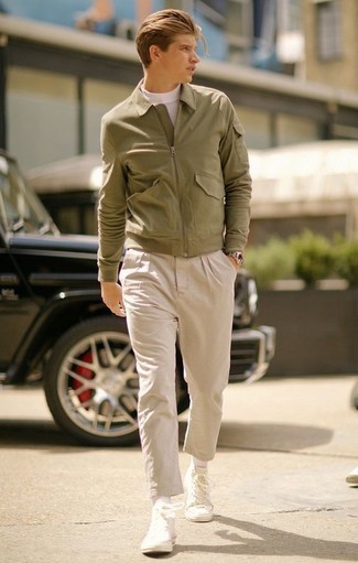 olivgrüne Harrington-Jacke, weißer Rollkragenpullover, hellbeige Chinohose, weiße hohe Sneakers aus Segeltuch für Herren