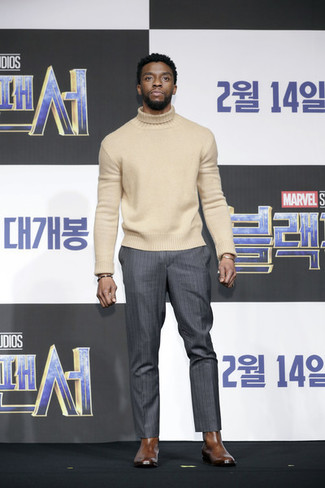 Chadwick Boseman trägt hellbeige Wollrollkragenpullover, dunkelgraue vertikal gestreifte Anzughose, braune Chelsea-Stiefel aus Leder