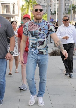 Conor McGregor trägt hellblaues bedrucktes T-Shirt mit einem Rundhalsausschnitt, hellblaue Jeans, hellbeige niedrige Sneakers
