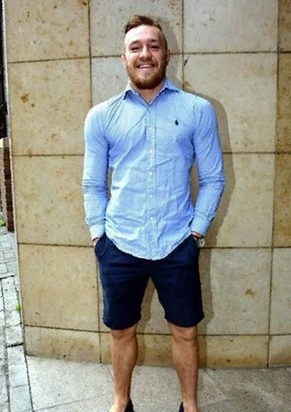 Conor McGregor trägt hellblaues Businesshemd, dunkelblaue Shorts, goldene Uhr