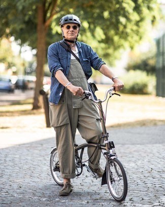 Olivgrüne Latzhose kombinieren – 8 Herren Outfits: Kombinieren Sie ein dunkelblaues Jeanshemd mit einer olivgrünen Latzhose für einen entspannten Wochenend-Look. Komplettieren Sie Ihr Outfit mit olivgrünen Segeltuch niedrigen Sneakers.