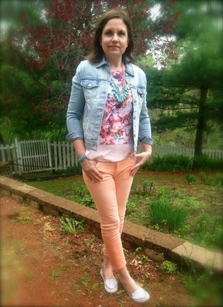 hellblaue Jeansjacke, rosa ärmelloses Oberteil mit Blumenmuster, orange enge Jeans, weiße Leder Slipper für Damen
