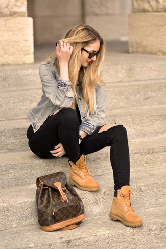 hellblaue Jeansjacke, schwarze enge Jeans mit Destroyed-Effekten, beige flache Stiefel mit einer Schnürung aus Wildleder, dunkelbrauner bedruckter Leder Rucksack für Damen
