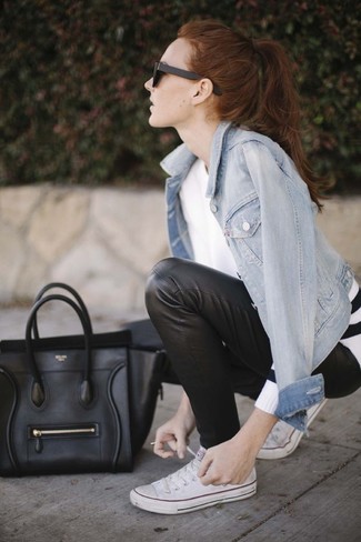 hellblaue Jeansjacke, weißer Pullover mit einem Rundhalsausschnitt, schwarze enge Hose aus Leder, weiße Segeltuch niedrige Sneakers für Damen