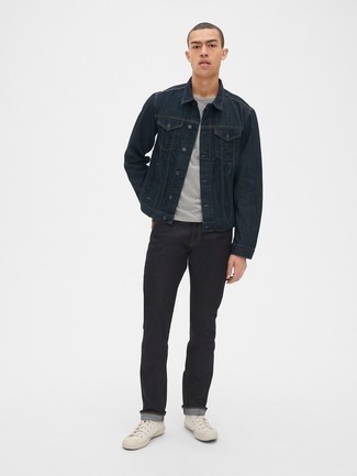 schwarze Jeansjacke, graues T-Shirt mit einem Rundhalsausschnitt, schwarze Jeans, weiße hohe Sneakers aus Segeltuch für Herren